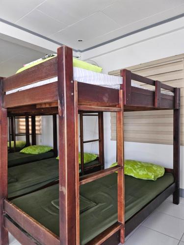 un groupe de lits superposés dans une pièce dans l'établissement L & M Hearthstones Lodge, à Oslob
