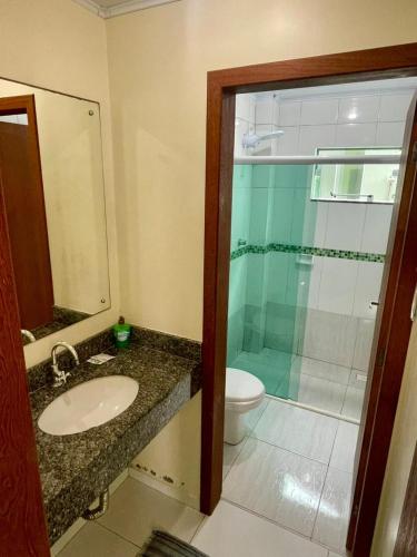 a bathroom with a shower and a sink and a toilet at Residencial Esmeralda-Vista ao Mar in Palhoça