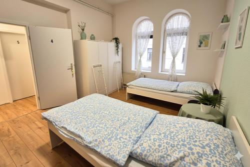 ein Schlafzimmer mit zwei Betten und zwei Fenstern in der Unterkunft L21-Apartment Flensburg, 5 Zimmer, 14 Betten, Standardisierte Ausstattung, ideal für Reisende, Pendler, Familien in Flensburg