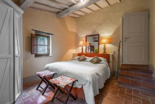 a bedroom with a large bed and two chairs at Casa Dell'Ambasciatore in Vivo dʼOrcia