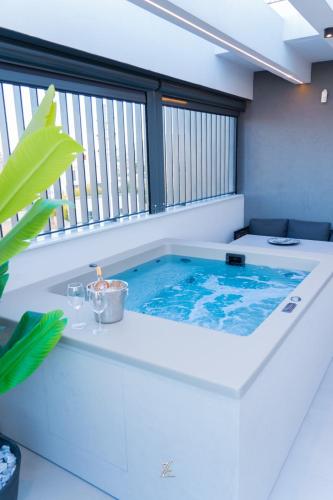 ein Whirlpool in einem Zimmer mit Fenster in der Unterkunft The Modern in Eleusis