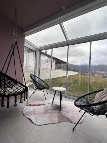 a room with a hammock and chairs and a large window at Apartment Una in Kupres