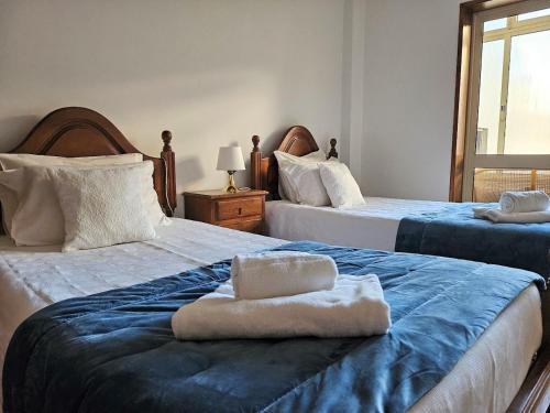a bedroom with two beds with towels on them at LUCINDA`S HOUSE in Braga