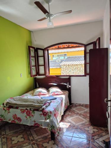 ein Schlafzimmer mit einem Bett und einem Fenster in der Unterkunft Pousada do Luar in São Thomé das Letras