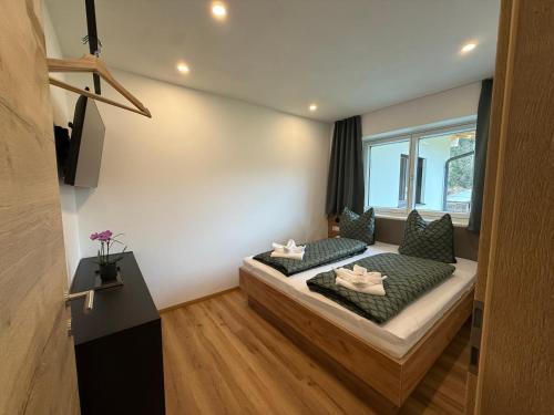 Habitación con cama con almohadas y ventana en Haus Schernthaner, en Saalbach Hinterglemm