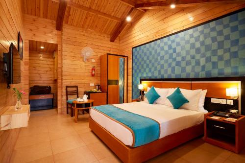1 Schlafzimmer mit einem großen Bett und einem Badezimmer in der Unterkunft Sterling Anaikatti in Varagampadi