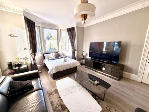 a living room with a couch and a flat screen tv at Immanuel House - Modern Luxury Victorian Home 1872 - Free Parking & SuperFast Fibre Optic WiFi in Edinburgh