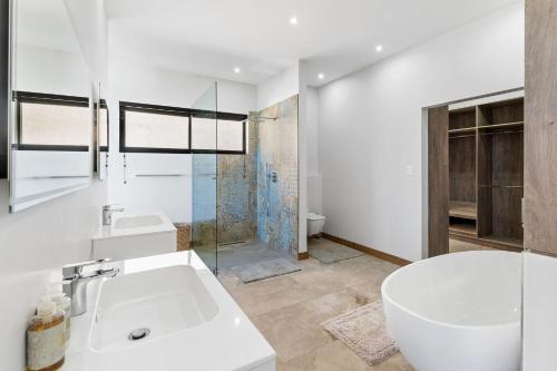 Outeniqua Strand31 Flamink Crescent Ave by Host Agents的带浴缸和水槽的白色浴室