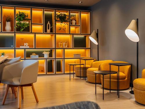 une salle d'attente avec des chaises et des tables jaunes dans l'établissement Ibis Florianopolis, à Florianópolis