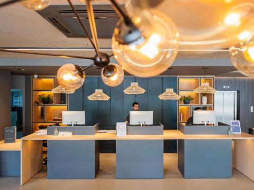 un homme est assis à un bureau dans un bureau dans l'établissement Ibis Florianopolis, à Florianópolis