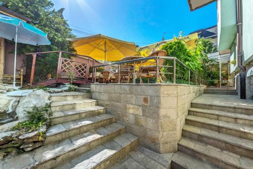 Eine Treppe, die zu einem Restaurant mit einem Regenschirm führt in der Unterkunft Hotel Darling in Bankja