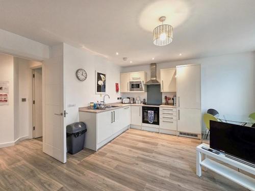 a large kitchen with white cabinets and a table at The Post House One by Fortuna Property Portfolio in Gloucester