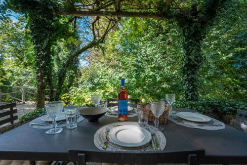 a table with plates and glasses and a bottle of wine at Casa Dell'Ambasciatore in Vivo dʼOrcia