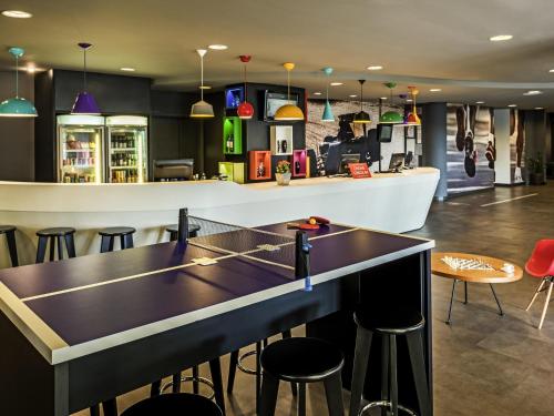 une table de ping-pong dans un bar avec des tabourets dans l'établissement ibis Sao Paulo Interlagos, à São Paulo