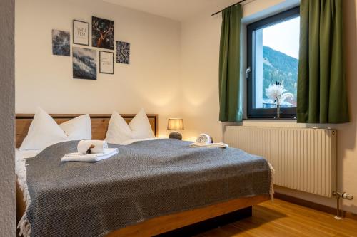 a bedroom with a bed with two stuffed animals on it at Bergblick Appartements in Bad Gastein