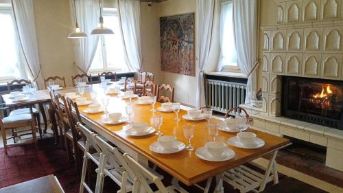 ein Esszimmer mit einem langen Tisch und einem Kamin in der Unterkunft Charmant gîte vosgien avec 9 chambres pour 22 personnes in Fellering