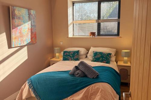 ein Bett in einem Schlafzimmer mit zwei Kissen darauf in der Unterkunft Trendy Barn Conversion Families & Groups Sleeps 8 in Midsomer Norton