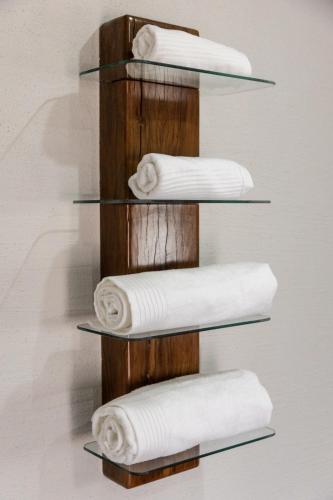 a wooden towel rack with four rolled towels at Landrift Villa in Phalaborwa