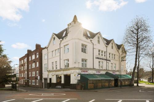 a white building on the corner of a street at London Star Hotel in London