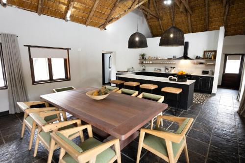 a kitchen and dining room with a wooden table and chairs at Landrift Villa in Phalaborwa