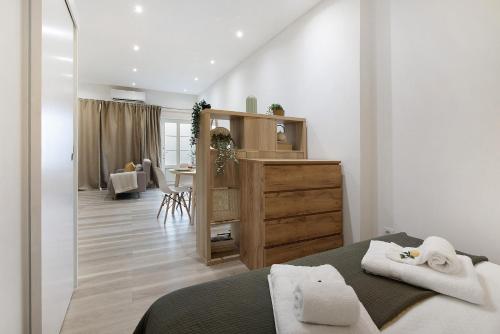 a bedroom with a bed and a dresser with towels at Central Studio – Flor De Sol in Tavira