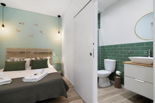a bedroom with a bed and a bathroom with a sink at Central Studio – Flor De Sol in Tavira