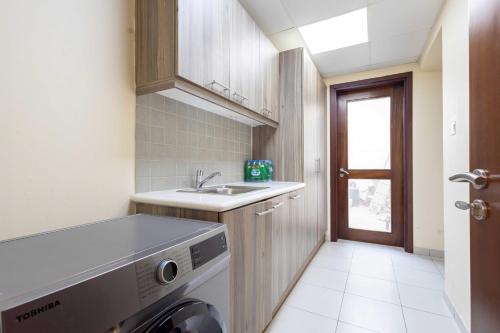 a small kitchen with a sink and a dishwasher at Malibu Luxe I Priavte Pool I 5 bed Villa in Ras al Khaimah