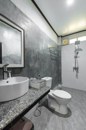 a bathroom with a sink and a toilet at VangVieng Charming Boutique Hotel in Vang Vieng