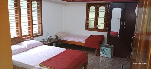 ein Schlafzimmer mit zwei Betten und einem Spiegel in der Unterkunft Vanashree Homestay Galamudi in Sringeri