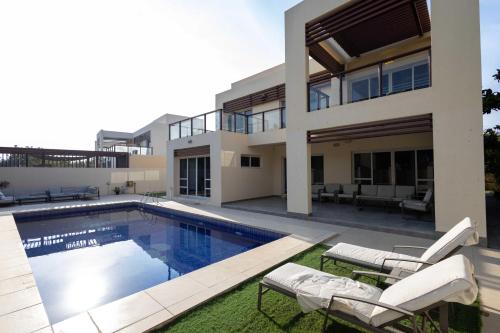 a house with a swimming pool in front of it at Malibu Luxe I Priavte Pool I 5 bed Villa in Ras al Khaimah