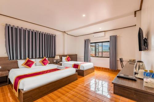 a hotel room with two beds and a desk at VangVieng Charming Boutique Hotel in Vang Vieng