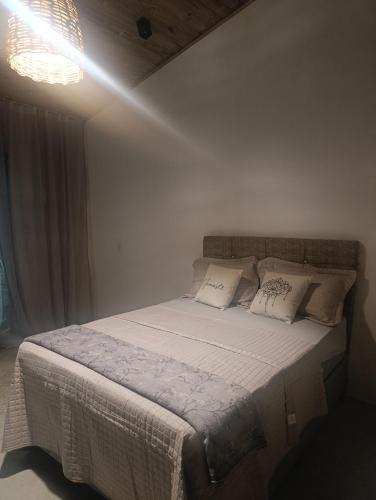 a bedroom with a bed with white sheets and pillows at Vila Mar Lofts in Barra Velha
