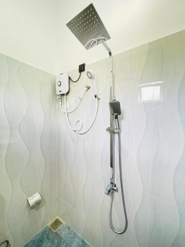 a shower with a shower head in a bathroom at Sanu Surfing Villa in Weligama