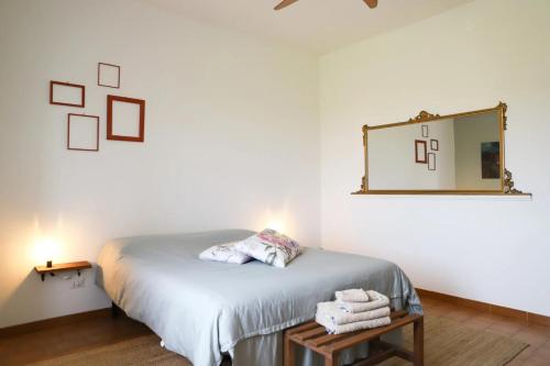 特雷斯努拉吉斯Anima Sarda Bed & Wine的卧室里有一张床，床边有一面镜子，还有一张桌子