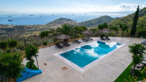 Una vista aérea de una piscina con sillas y sombrillas. en Prosili, en Aiándion