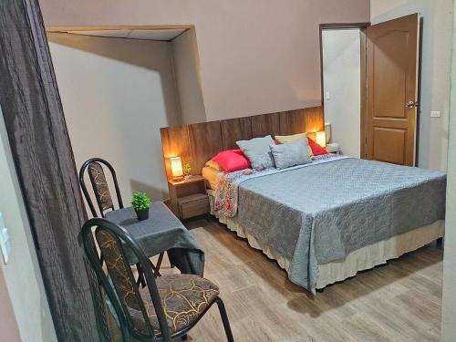 Un dormitorio con una cama y una silla dentro. en Punto Terra, en Tegucigalpa