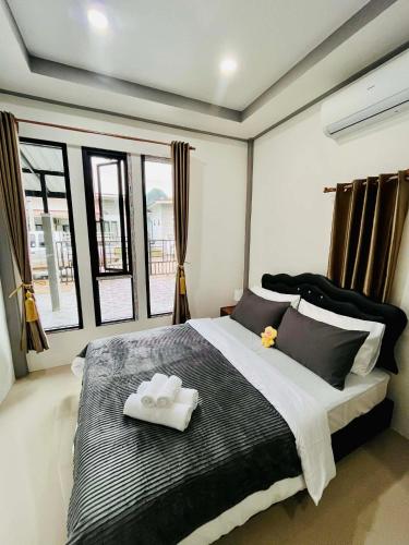 a bedroom with a large bed with two towels on it at Cozy Hideaway 2 BR Private Room Shared House in Ban Tha Khun
