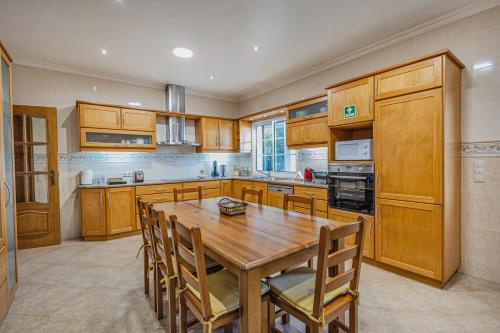 a kitchen with wooden cabinets and a wooden table at Casa dos Amigos in Pico da Pedra