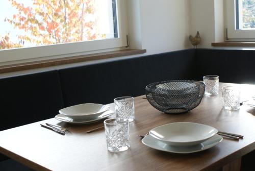 une table en bois avec des assiettes et des verres dans l'établissement Alpenglow Apartments, à Collalbo