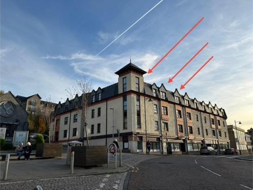 a large building with contrails in the sky at Apartment in Highlands of Scotland - Fort William in Fort William