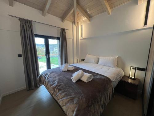 a bedroom with a large bed with two pillows on it at Arachova Villa Paris in Kalívia