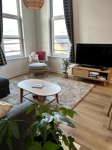 a living room with a tv and a coffee table at Apartment in Highlands of Scotland - Fort William in Fort William