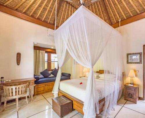 a bedroom with a bed with mosquito net at Arjuna Villa 3 Bedroom Villa Seminyak in Seminyak