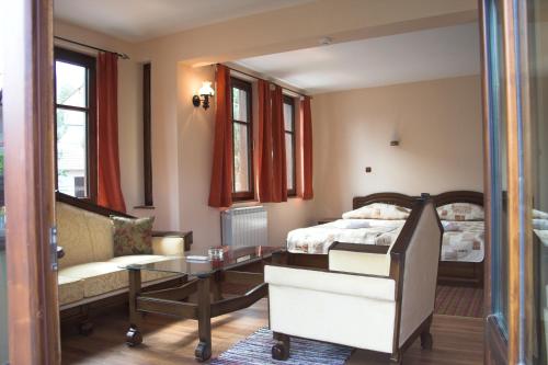a bedroom with a bed and a table and a couch at Hotel Old Times in Asenovgrad