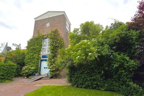 un bâtiment en briques avec une porte bleue dans une cour dans l'établissement Hello Zeeland - Noordstraat 13-01, à Domburg