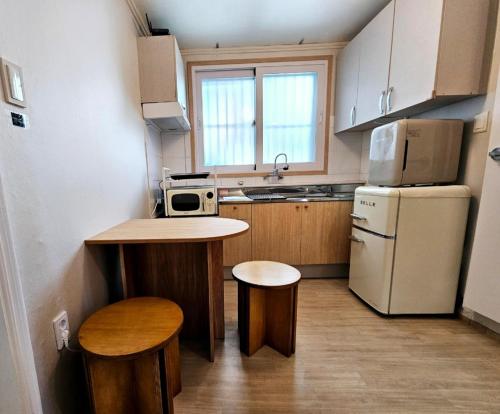 a small kitchen with a counter and a refrigerator at 숲애스테이 in Hagwanggyo-dong
