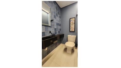 a bathroom with a toilet and a sink at Dream Apartment-Rooftop, Pool, Mountain & Sea View in Capão da Canoa