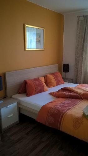a bedroom with two beds with orange pillows at Landhotel SONNENHOF MotorradKrauk in Ulrichsberg