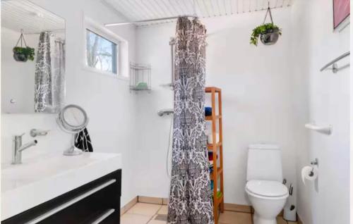 a bathroom with a sink and a shower curtain at Dejligt Sommerhus Tæt Ved Lammefjorden in Kisserup