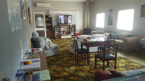 
a living room filled with furniture and a tv at Tingle All Over Budget Accommodation in Walpole
